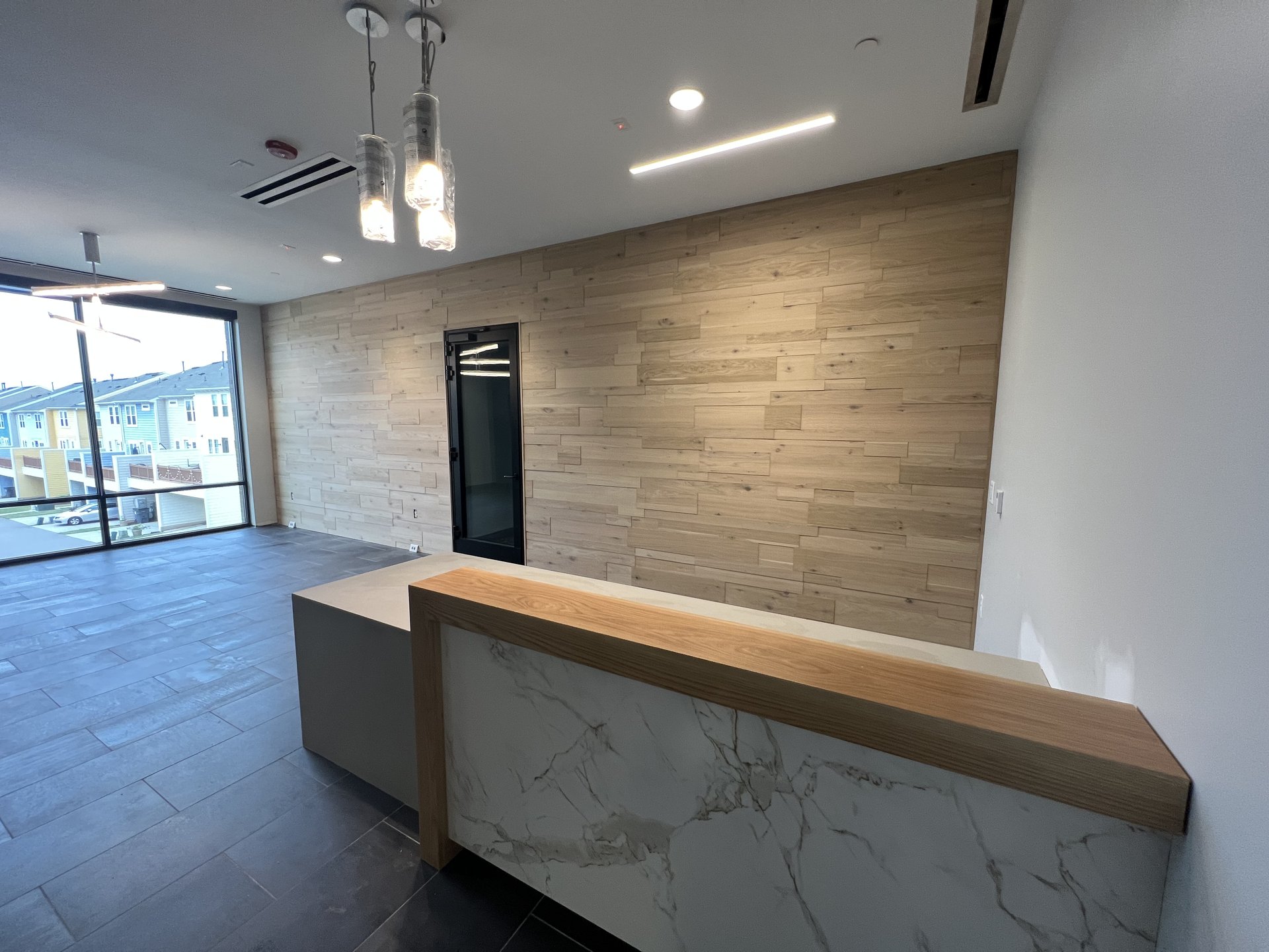 Reception desk with quartz waterfall edge and wood accent wall