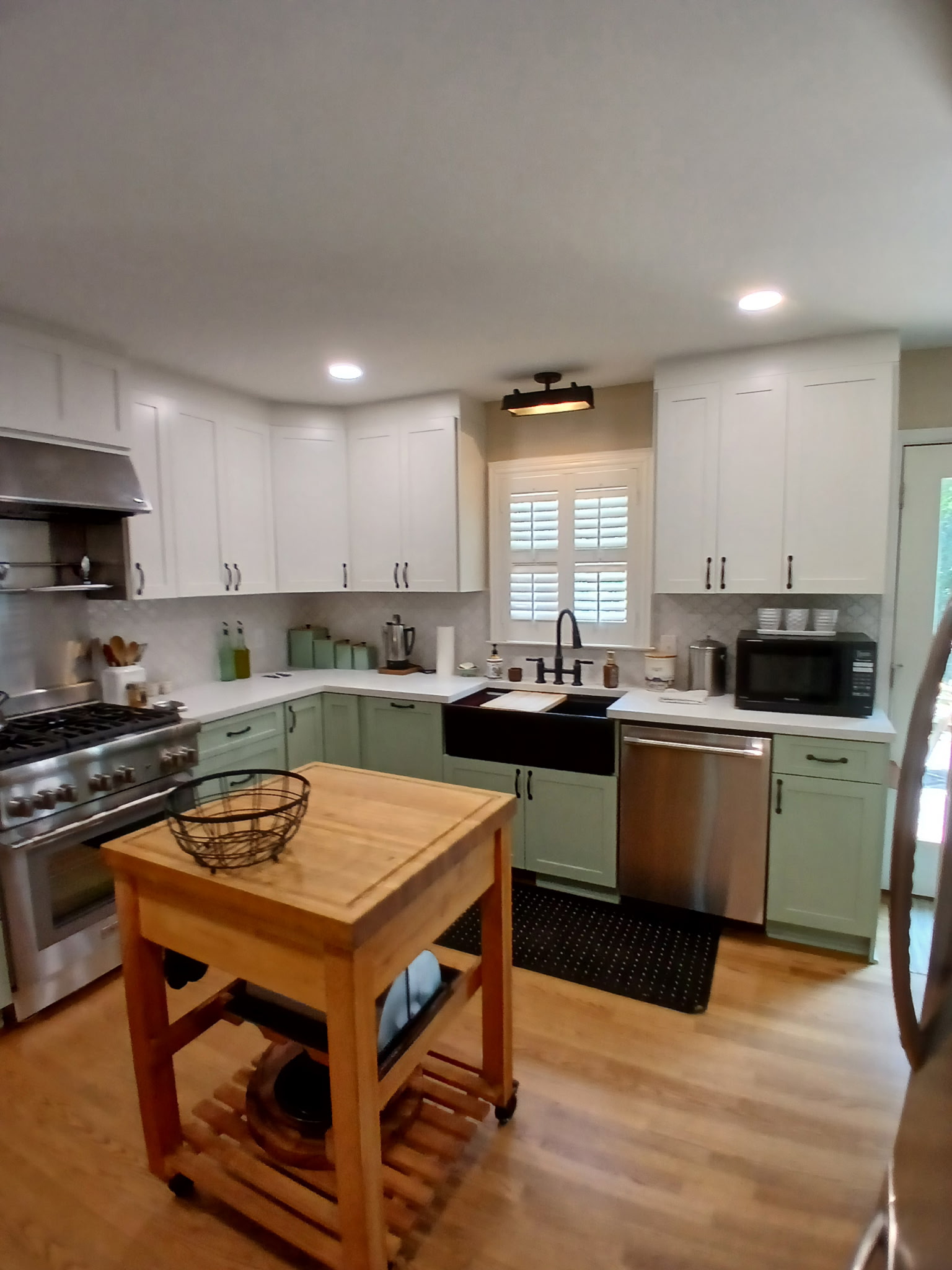Sage and white kitchen with black farmhouse sink